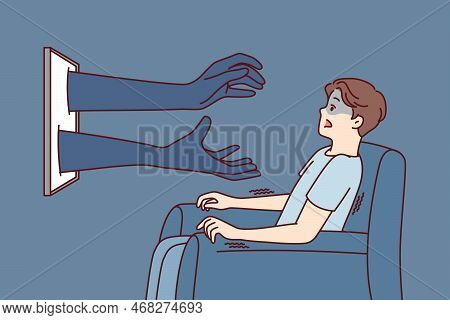 Man Sitting In Chair In Front Tv Gets Scared When Sees Hands Reaching Out From Display. Shocked Guy 