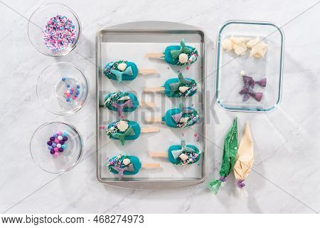Flat Lay. Decorating Cakesicles With Drizzled Chocolate, Chocolate Mermaid Tails, And Seashells.