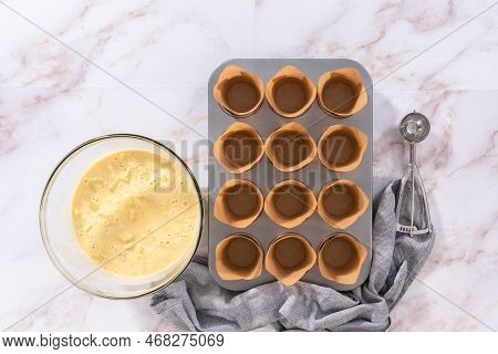 Flat Lay. Scooping Dough Into The Cupcake Pan Lined With Parchment Muffin Liners To Bake Sharlotka M