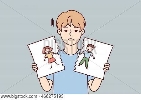 Sad Boy With Blond Hair Holds In Hands Torn Pictured With Painted Kids. Cheerless Child Of Pree Teen