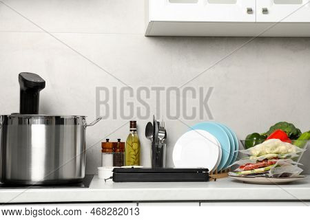 Pot With Thermal Immersion Circulator, Sealer And Vacuum Packed Food Products In Kitchen. Sous Vide 