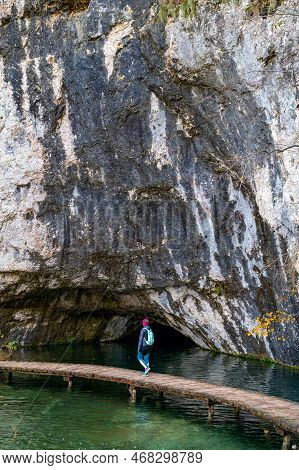 Young Woman Tourist Walking In Plitvice Lakes National Park During Colorful Autumn, Croatia, Europe.
