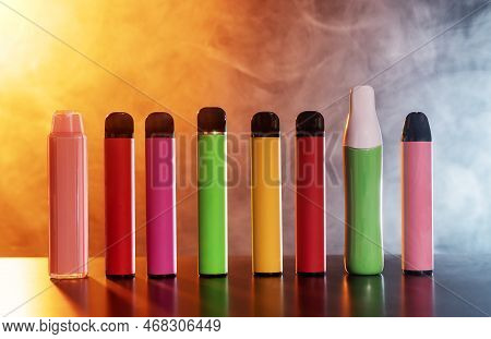 A Set Of Colorful Disposable Electronic Cigarettes Of Different Shapes On A Black Background With Sm