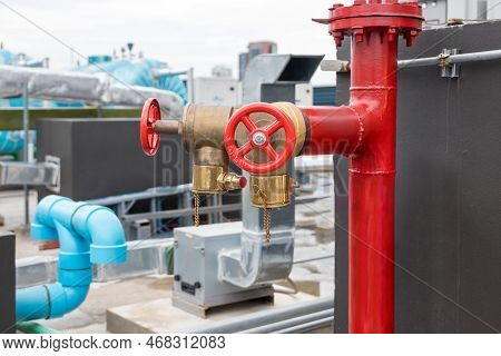 Red Fire Pump In Front Of Concrete Wall. Fire Safety Pump On Cement Floor Of Concrete Building. Delu