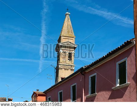 View Of The Top Of The Leaning Bell Tower Of The Church Of San Martino Vescovo Against A Blue Sky On