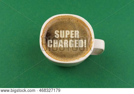 On A Green Surface There Is A White Cup With Coffee, On The Coffee Foam There Is An Inscription - Su