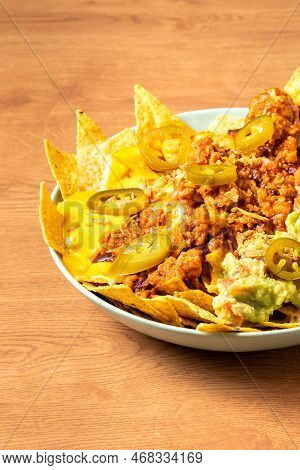 Corn Chips Nachos With Fried Minced Meat And Guacamole On Wooden Background. High Quality Photo