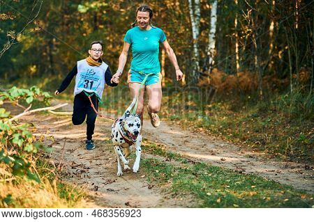Svetly, Kaliningrad Oblast, Russia - October 2, 2021 - Canicross Exercises, Mother And Her Son Runni