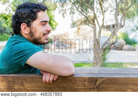 Portrait Of A Casual Tired Man Resting Sitting On Bench At City Park.