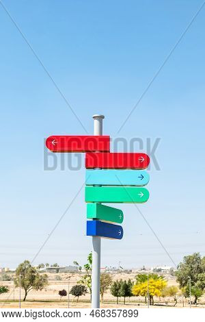 Blank Signpost With Many Directions Against Blue Sky In Sunny Day. Mockup. Copy Space.