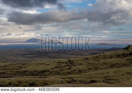 Country Covered By Lichen And Grass. Dark Blue Water Of The Lake Thingvallavatn. Mountains Covered B