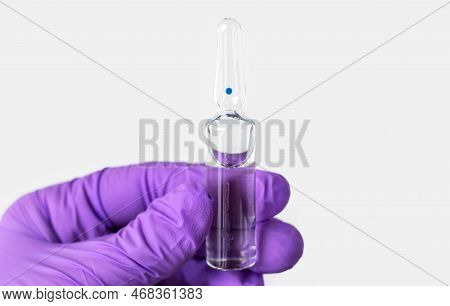 Woman Doctor In Purple Gloves Isolated In Gray Holding Sodium Chloride Solution In Glass Ampule Tryi