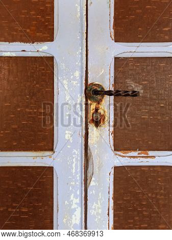 Close Up Of Old Door With Rusty Latch And Lock. Rust On Metal Lock And Rotten Wooden Door. Architect