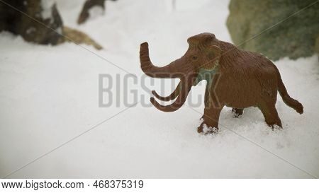 Figurine Of A Mammoth In The Snowy Mountains. Mammoth In The Snow.