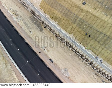 Mountain Road Constraction. Workers Reinforce The Slope Over The New Road. Road Construction In Prog