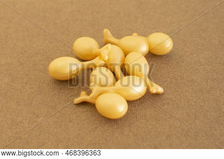 Capsules With A Cream Or Serum For Face Treatment On Beige Background. Single Dose Capsules For Beau
