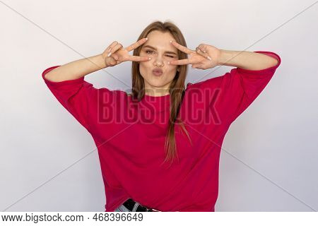 Cheerful Young Woman Showing V-signs Near Eyes. Caucasian Female Model With Brown Hair And Green Eye
