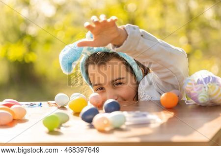 Teenage Girl Paints Easter Eggs In The Garden.