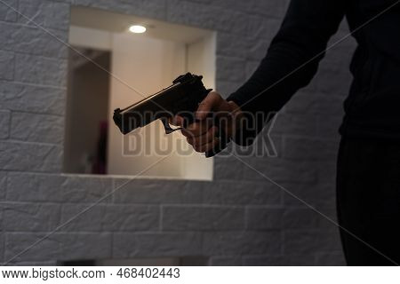 Male Hand Holding A Gun On Black Background . A Gun In A Mans Hand. Defense Or Attack Murderer Or Ar