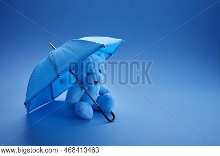 Blue Teddy Bear With Umbrella On Blue Background. Blue Monday Concept.