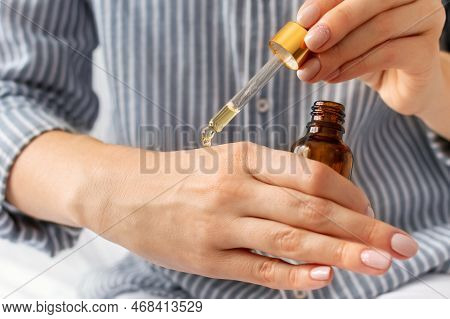 Close-up Of Young Caucasian Woman Applies Moisturizing Nourishing Oil On Her Hands. Hand Skin Care, 