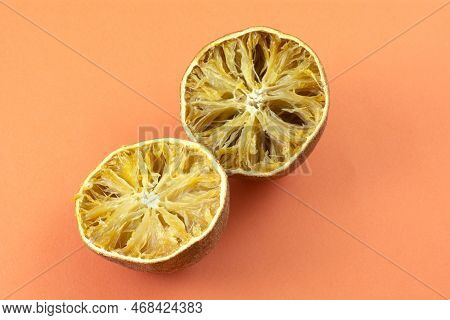 Dried Out Inedible And Rotten Oranges Spoiled From Improper And Lengthy Storage On Orange Background