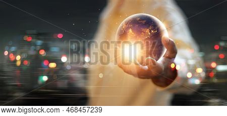 Earth At Night Was Holding In Human Hands On The Sunset Sky. Earth Day. Energy Saving Concept, Eleme