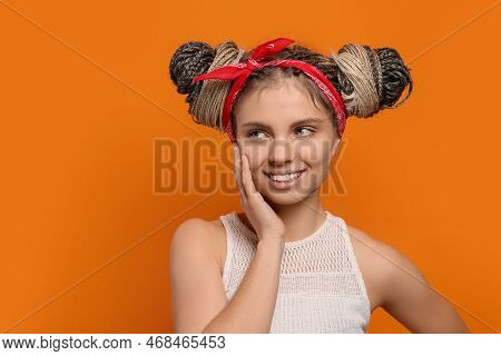 Beautiful Woman With Braided Double Buns On Orange Background, Space For Text