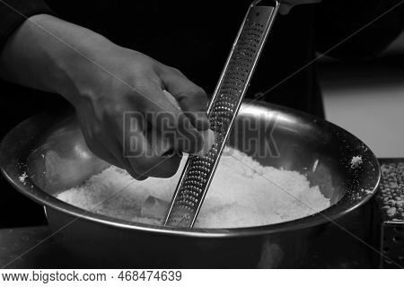 Chef Grating Parmesan Cheese With Fine Grater  In Close Up