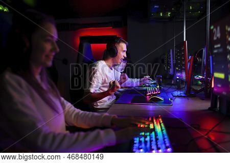 Emotional Guy Gamer In Headphones Sits In A Computer Club And Plays A Computer Game, A Man Screaming
