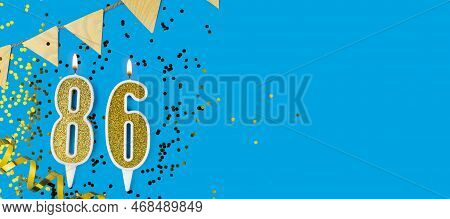Golden Candle Number Eighty Six. Birthday Or Anniversary Card With The Inscription 86 On Blue Backgr