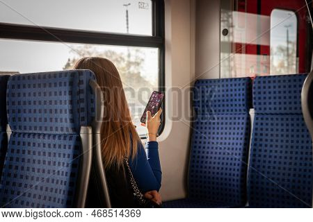 Cologne, Germany - November 12, 2022: Selective Blur On Young Girl, Generation Z, Sitting In An Sbah