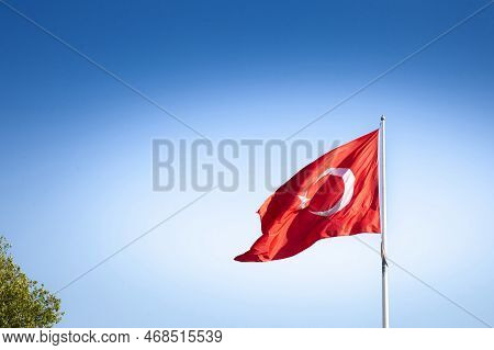 Turkish Flag Floating In The Air In Front Of A Blue Sky In Istanbul. Also Called Turk Bayragi, The F