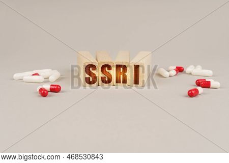 Medical Concept. On A Gray Surface Are Pills And A Red Wooden Block With The Inscription - Ssri