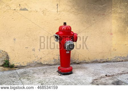 Fire Hydrant In Perpignan, France. Red Standpipe. Fire Safety Infrastructure.