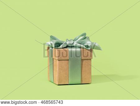 Buff Paper Gift Box With Green Ribbon Bow On Soft Green Background. Gift Or Holiday Concept. Mothers