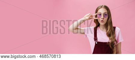 Portrait Of Stylish Energetic Girl With Scar On Hand Showing Peace Sign Over Eye Wearing Cool Sungla