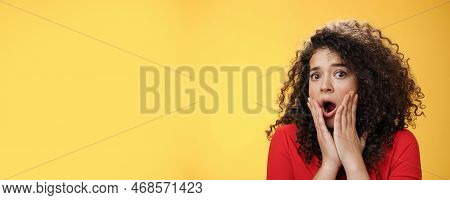 Indoor Shot Of Shocked Female Drama Queen With Curly Hair Gasping In Surprise, Feeling Empathy And F