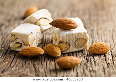  weißer Nougat mit Mandeln auf Holztisch