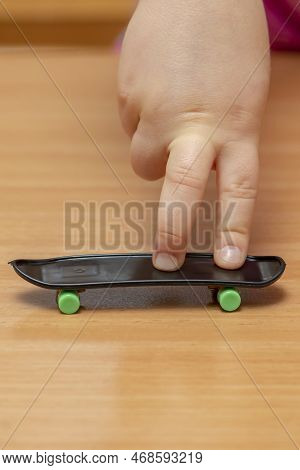 Fingers On A Fingerboard On A Wooden Surface, Close-up, Selective Focus. Fingerskate Finger Training