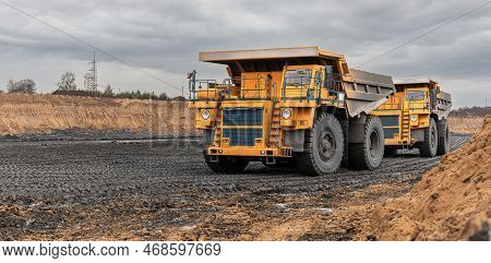 Large Quarry Dump Truck. Big Yellow Mining Truck At Work Site. Loading Coal Into Body Truck. Product
