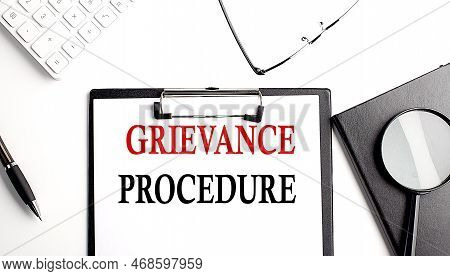 Grievance Procedure Text Written On A Paper Clipboard With Office Tools