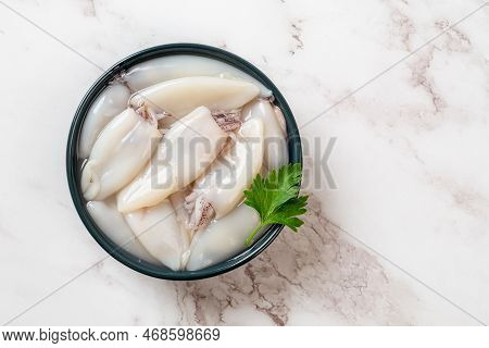 Raw Squid Fillet In A Bowl Over Marble Background. Small Calamary Tubes Prepared For Cooking. Fresh 