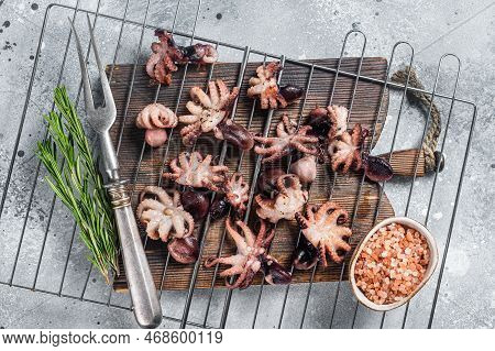 Grilled Baby Mini Octopuses On A Grill. Gray Background. Top View.
