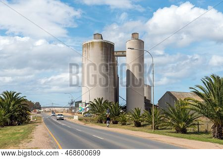 Bredasdorp, South Africa - Sep 23, 2022: A Street Scene, With Grain Silos, Palm Trees And Vehicles, 