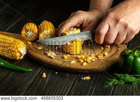 The Cook Cuts Corn Kernels With A Knife. Maize Is An Excellent Dietary Breakfast Or Lunch By The Che
