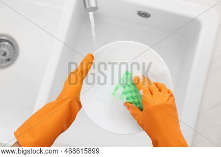 Woman Washing Plate Above Sink In Modern Kitchen, Top View