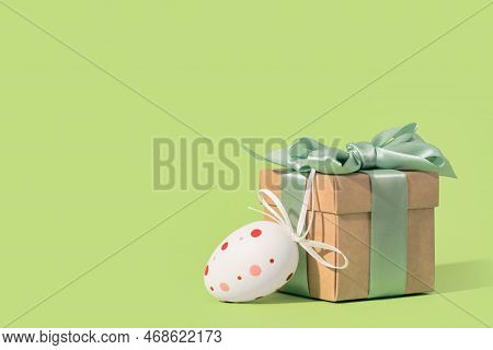 Happy Easter Minimal Concept. Painted Egg And Gift Box With Green Bow On Spring Yellow Green Edgeles
