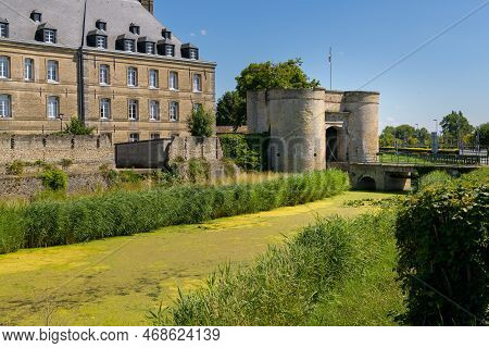 Bergues, France - July 5. 2022: An Old City Wall With Surveillance Towers, City Gate And Bridge, Cle