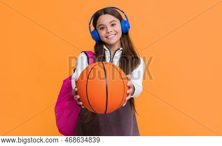 Happy Child In Headphones With School Backpack And Basketball Ball. Selective Focus